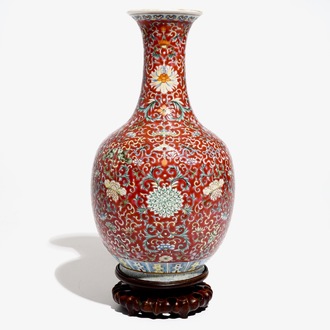 A Chinese red-ground famille rose bottle vase, Qianlong mark, 19/20th C.